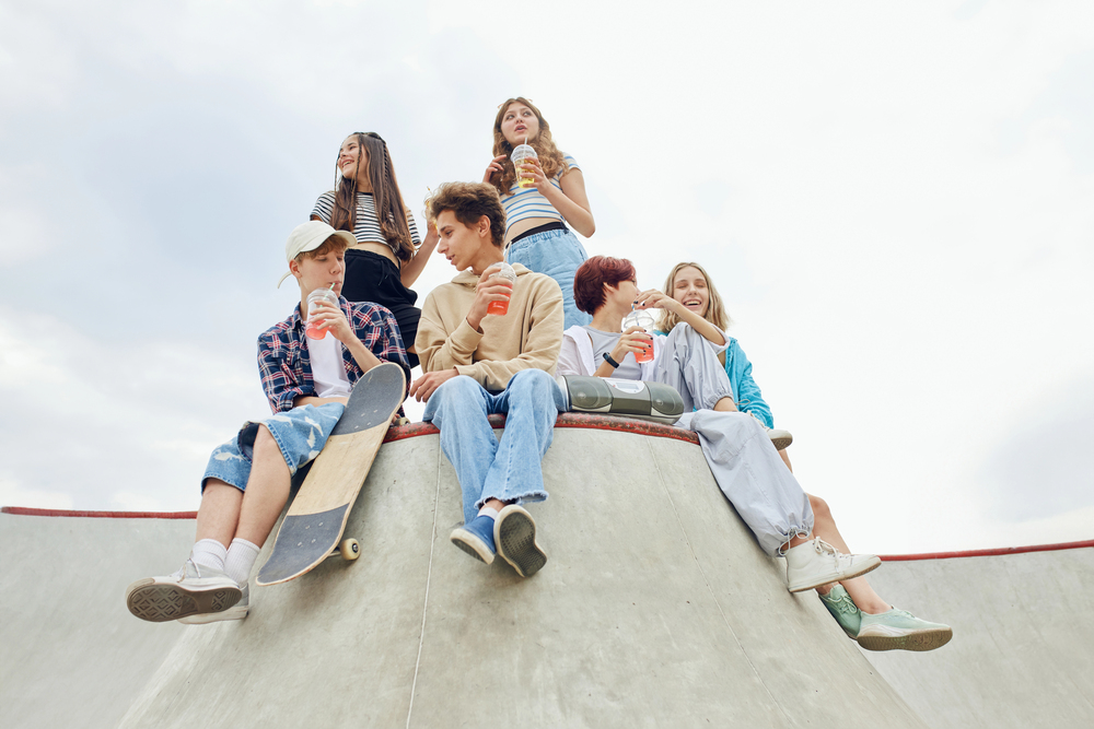 grupa nastolatków siedzi na skateparku